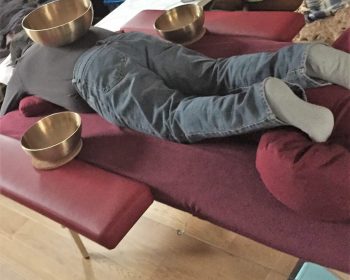 photo d'une personne recevant un massage en position ventrale avec 3 bols
