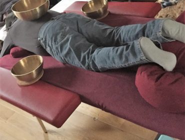 photo d'une personne recevant un massage en position ventrale avec 3 bols